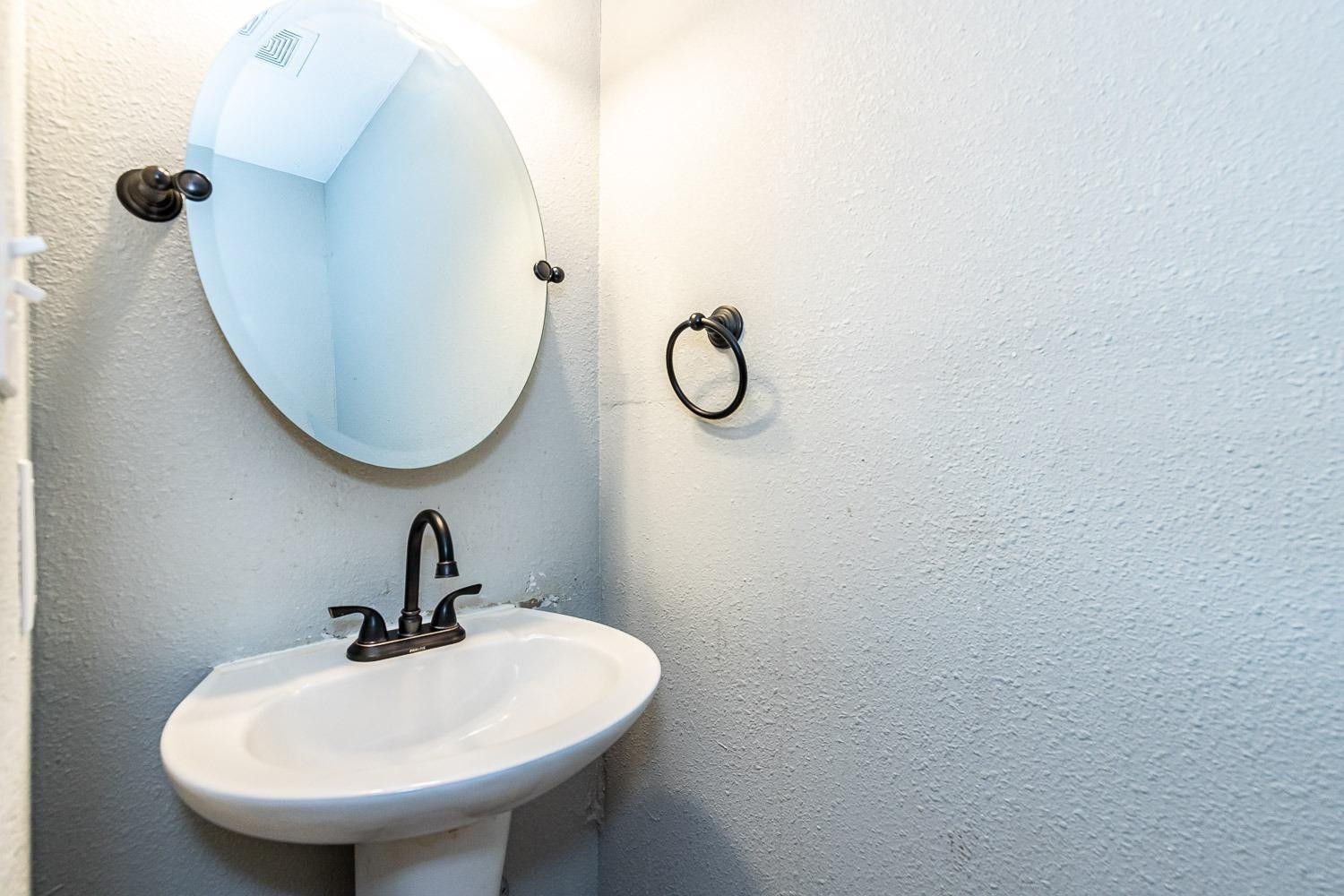 3411 42nd Street Lubbock, TX 79413 - Photo 25 of 33 a bathroom with a sink and mirror