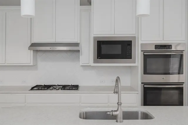 a kitchen with granite countertop a stove and a microwave