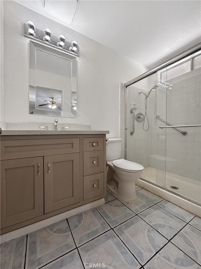 7451 Diamond Street Riverside, CA 92504 - Photo 17 of 31 a bathroom with a granite countertop sink a toilet and a mirror