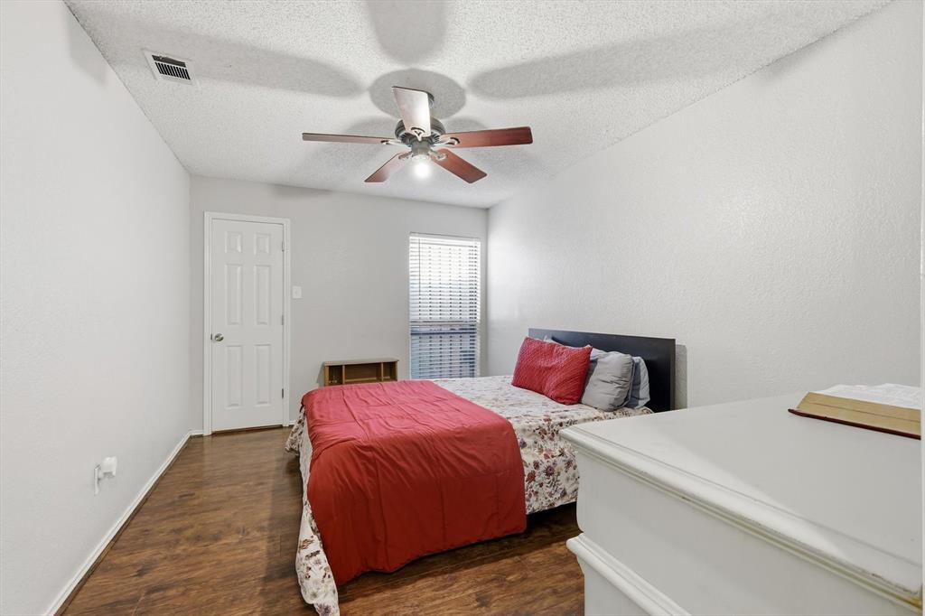 1312 Hackamore Street Mesquite, TX 75149 - Photo 16 of 23 Bedroom with dark wood-style flooring, a textured ceiling, a ceiling fan, and a textured wall