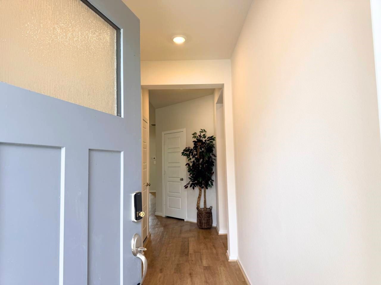 16246 Parish Pointe Court Conroe, TX 77302 - Photo 5 of 32 a view of a hallway with wooden floor and a living room