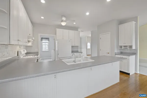 a spacious bathroom with a granite countertop sink a mirror and a shower
