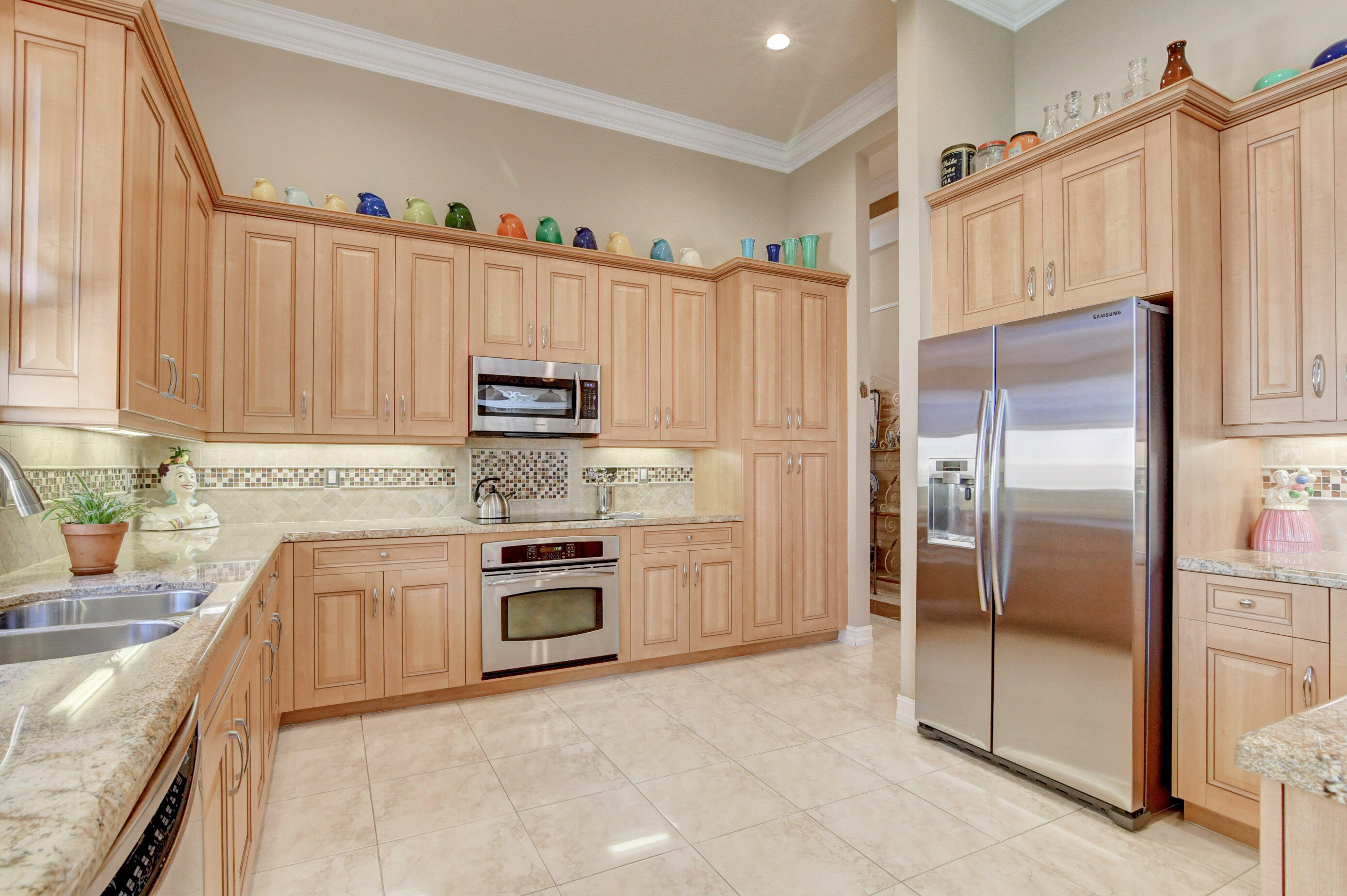 6863 Boscanni Drive Boynton Beach, FL 33437 - Photo 19 of 61 a kitchen with granite countertop a refrigerator and a sink
