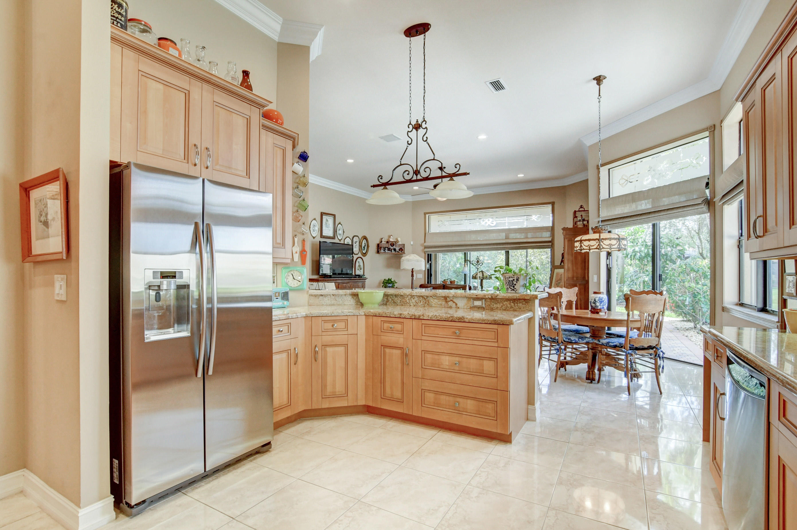 6863 Boscanni Drive Boynton Beach, FL 33437 - Photo 21 of 61 a kitchen with kitchen island granite countertop a center island a refrigerator and a view of living room