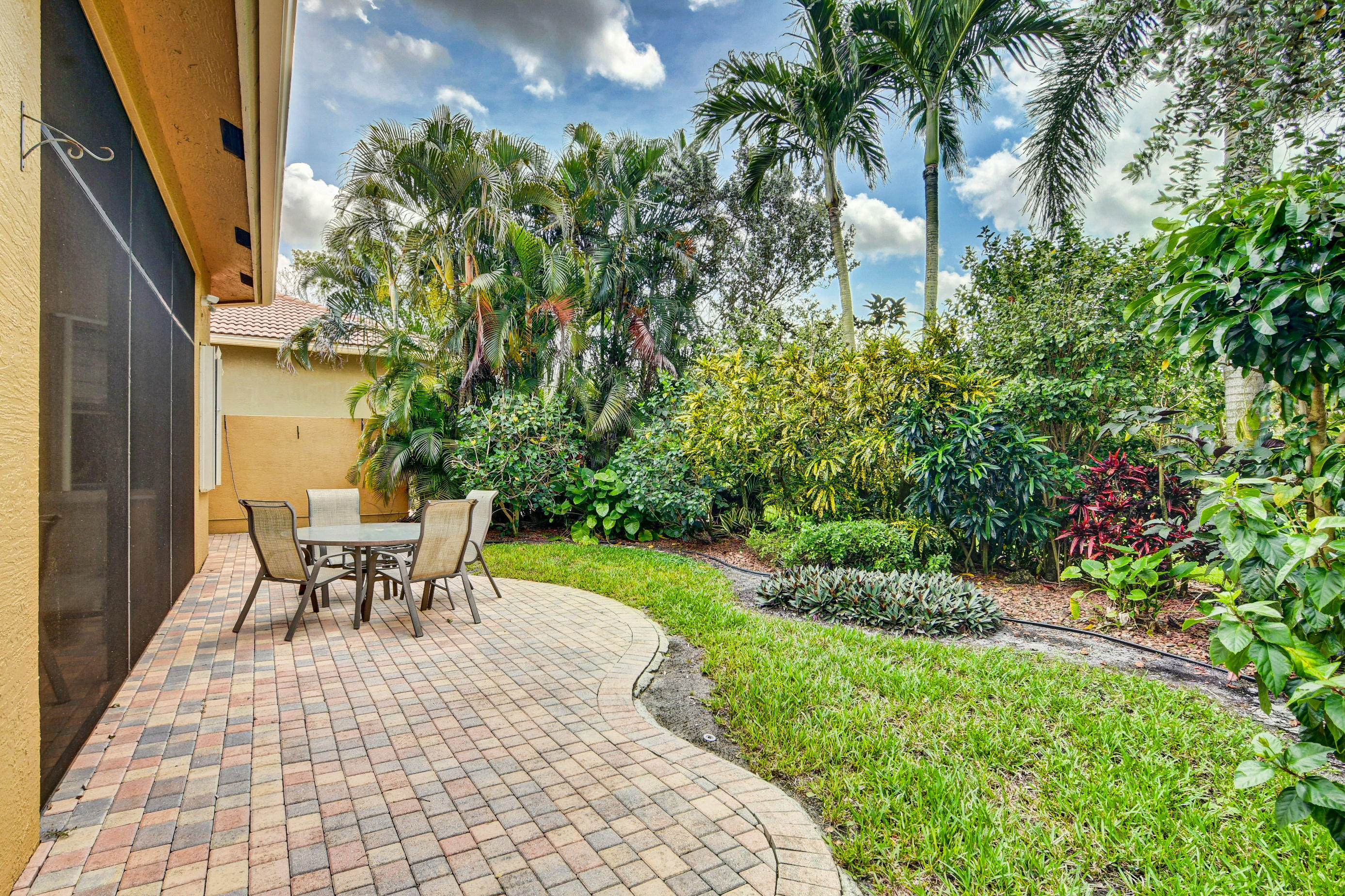 6863 Boscanni Drive Boynton Beach, FL 33437 - Photo 36 of 61 a view of a backyard with table and chairs and potted plants