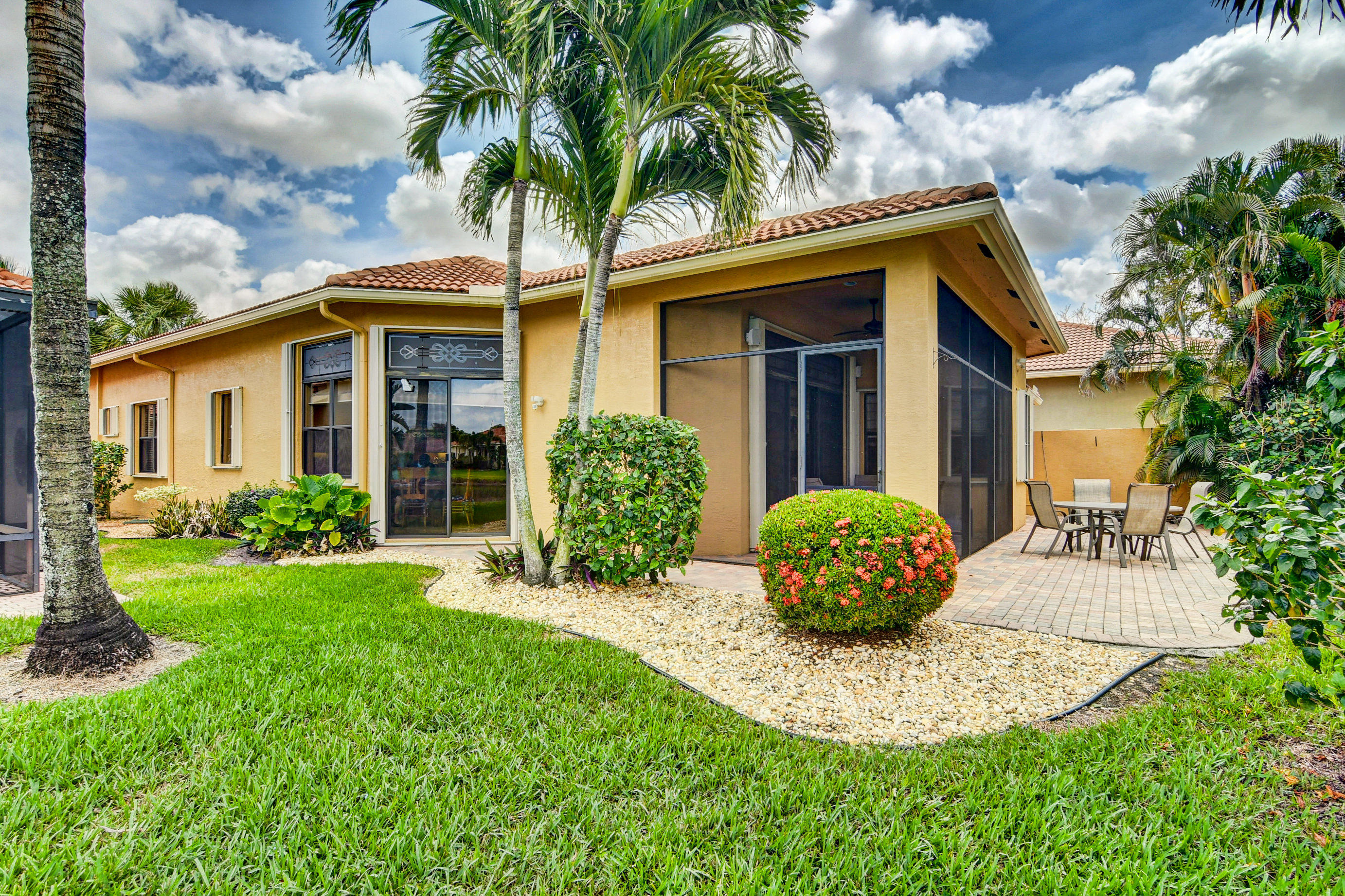 6863 Boscanni Drive Boynton Beach, FL 33437 - Photo 40 of 61 a view of a white house with a yard and potted plants