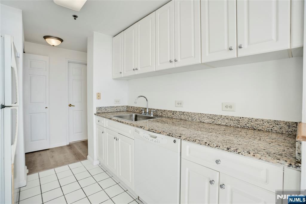 100 Old Palisade Road, Unit 2709 Fort Lee, NJ 07024 - Photo 8 of 15 a kitchen with granite countertop white cabinets and sink