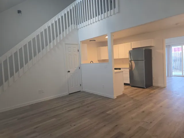 a view of an empty room with wooden floor and windows