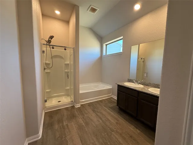 a bathroom with a tub sink shower and mirror