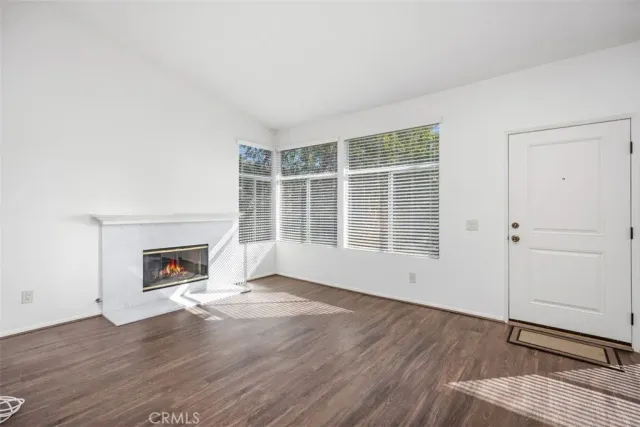 a view of a livingroom with wooden floor and a fireplace