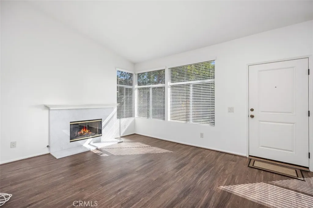 19431 Rue De Valore Lake Forest, CA 92610 - Photo 2 of 30 an empty room with wooden floor fireplace and windows