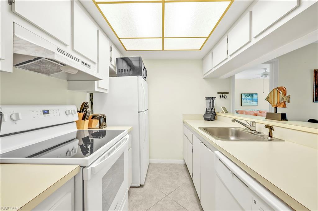 4287 27th Court Southwest, Unit 202 Naples, FL 34116 - Photo 13 of 17 a kitchen with a sink and a refrigerator