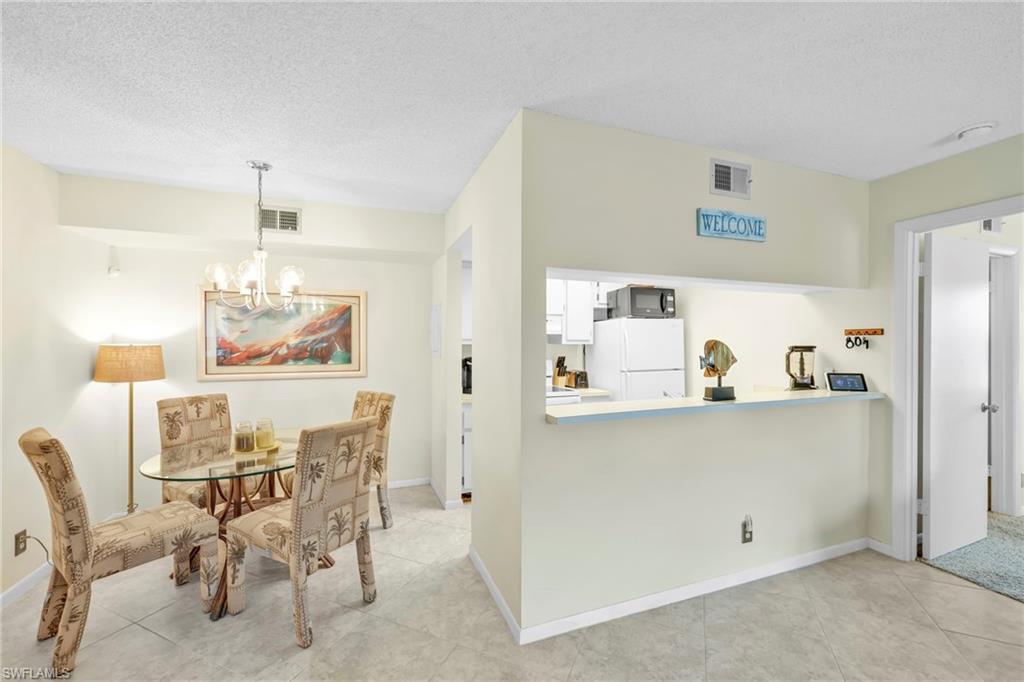 4287 27th Court Southwest, Unit 202 Naples, FL 34116 - Photo 14 of 17 a view of a dining room with furniture and chandelier