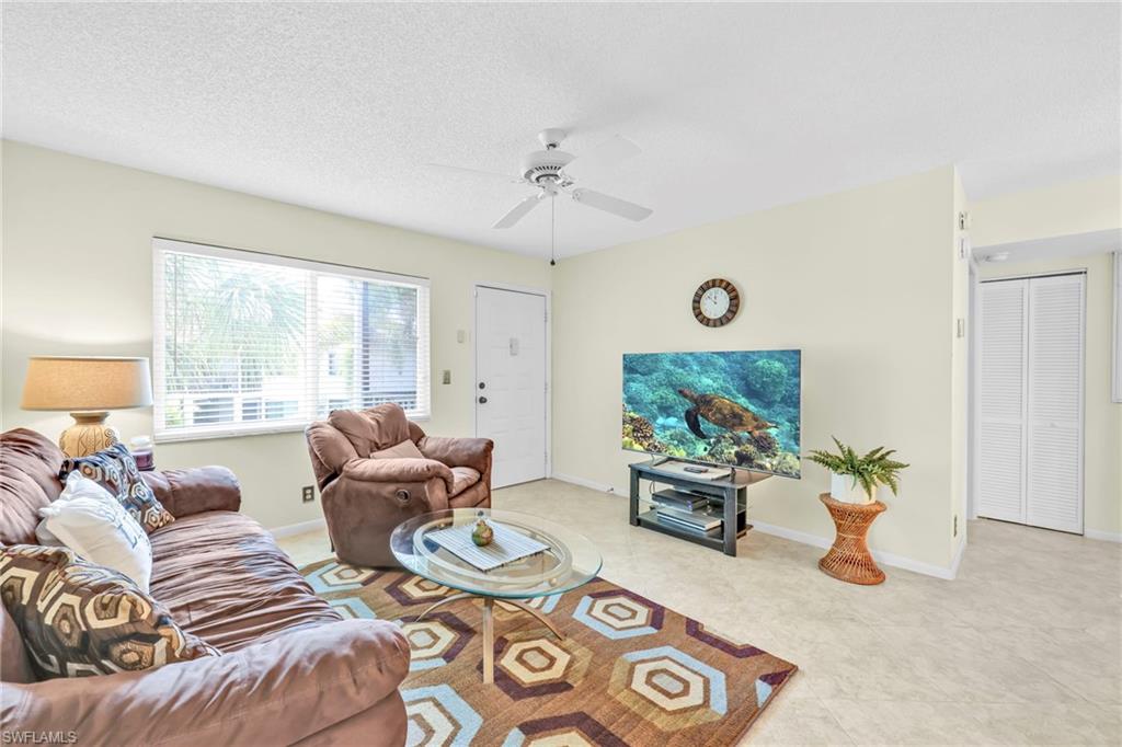 4287 27th Court Southwest, Unit 202 Naples, FL 34116 - Photo 16 of 17 a living room with furniture and a large window