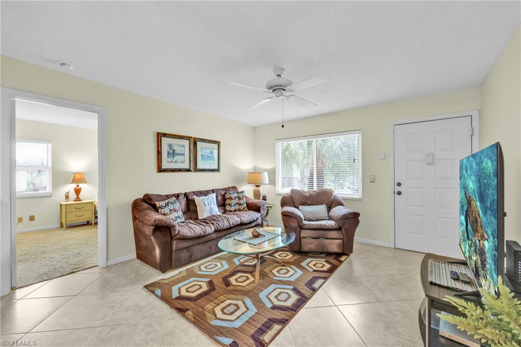 4287 27th Court Southwest, Unit 202 Naples, FL 34116 - Photo 17 of 17 a living room with furniture and a flat screen tv