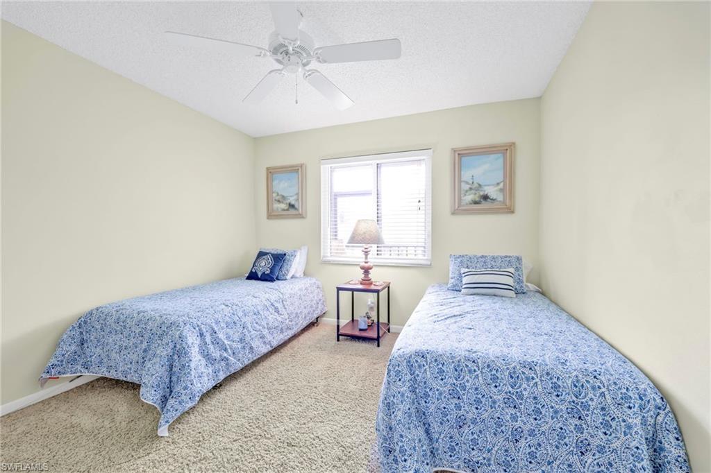 4287 27th Court Southwest, Unit 202 Naples, FL 34116 - Photo 5 of 17 a spacious bedroom with two beds and window