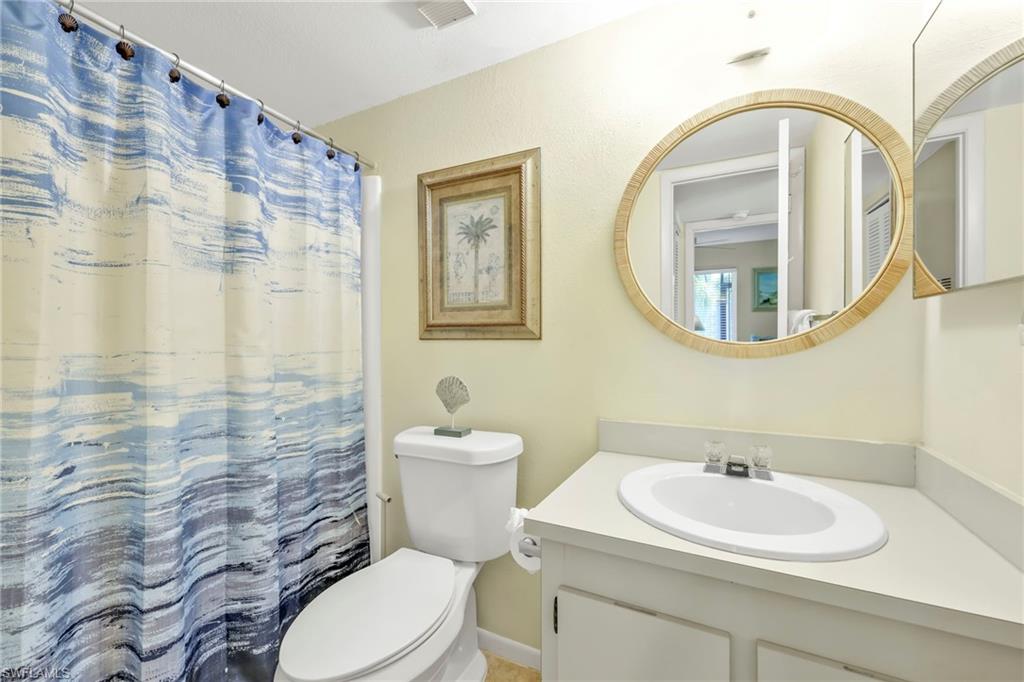 4287 27th Court Southwest, Unit 202 Naples, FL 34116 - Photo 6 of 17 a bathroom with a sink a toilet and a mirror