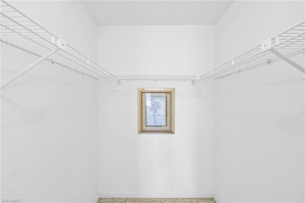 4287 27th Court Southwest, Unit 202 Naples, FL 34116 - Photo 7 of 17 a view of a hallway with a white wall and a large window