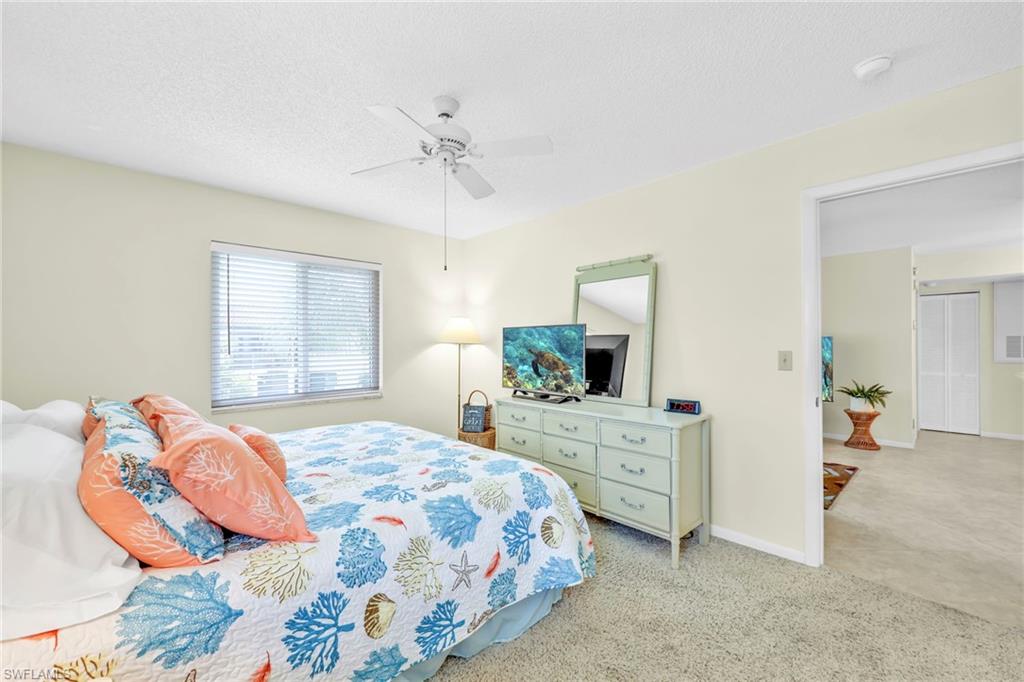 4287 27th Court Southwest, Unit 202 Naples, FL 34116 - Photo 10 of 17 a bedroom with a bed and a chandelier