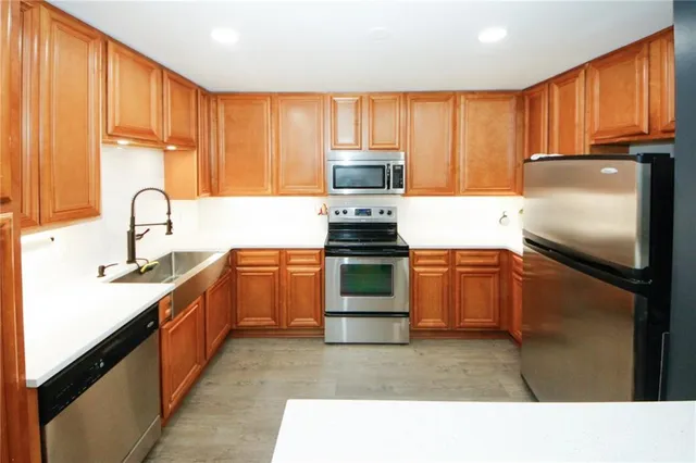 a kitchen with kitchen island granite countertop a stove sink and refrigerator