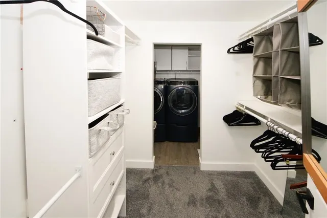 a view of walk in closet with clothes and shoes