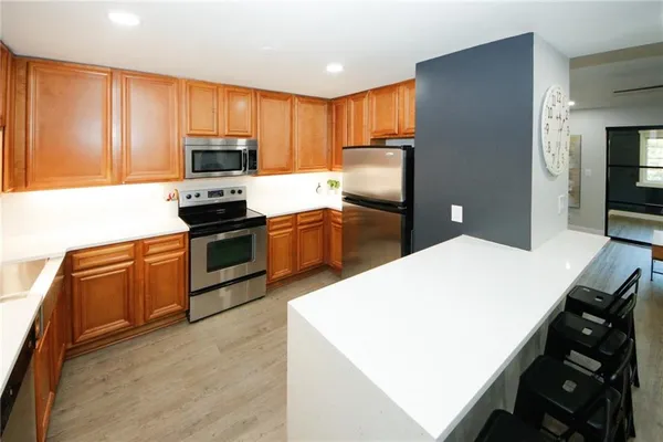 a kitchen with stainless steel appliances a stove refrigerator sink and microwave