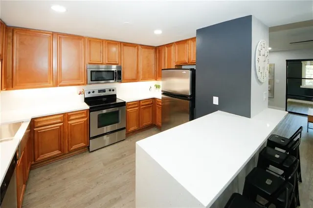 a kitchen with stainless steel appliances a stove refrigerator sink and microwave