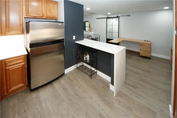 a kitchen with kitchen island a counter top space cabinets and stainless steel appliances