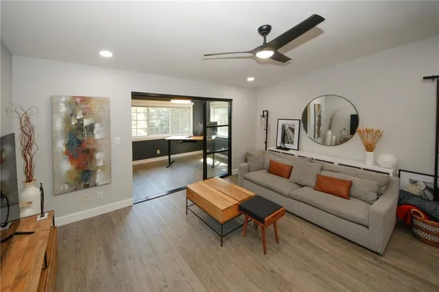 a living room with furniture a large window and a flat screen tv