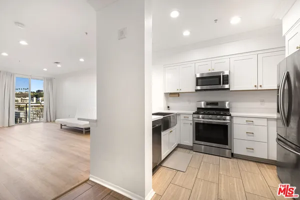 a kitchen with stainless steel appliances a stove a sink and a refrigerator