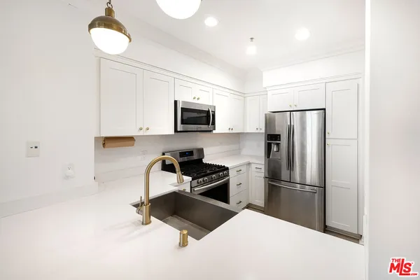 a kitchen with a refrigerator a microwave and cabinets