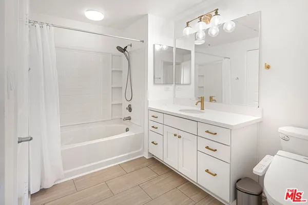 a bathroom with a tub sink toilet and mirror