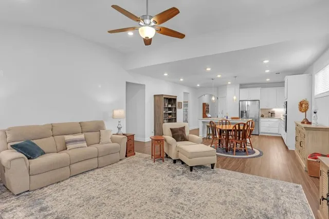 a living room with furniture and a view of kitchen