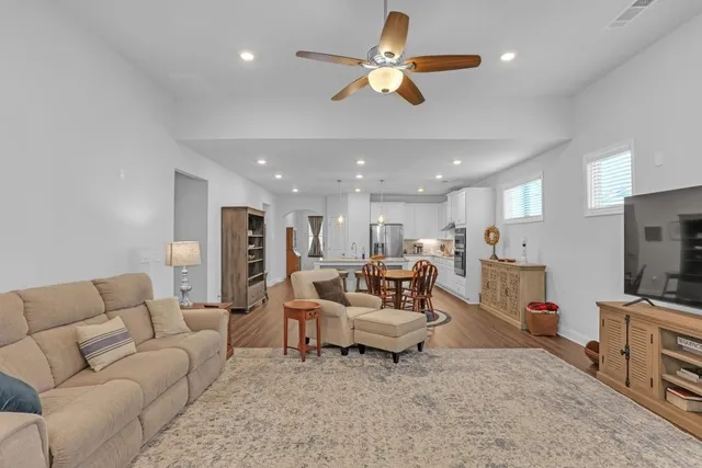 a living room with furniture kitchen view and a chandelier