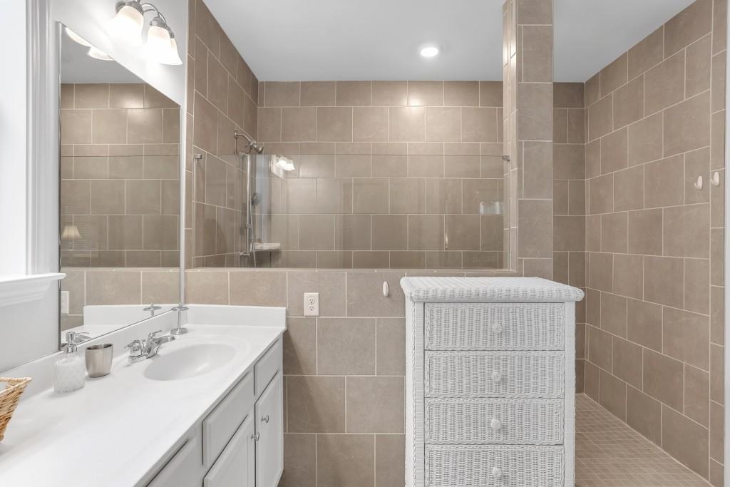 1598 Auburn Rdg Way Dacula, GA 30019 - Photo 20 of 34 a bathroom with a double vanity sink mirror and shower
