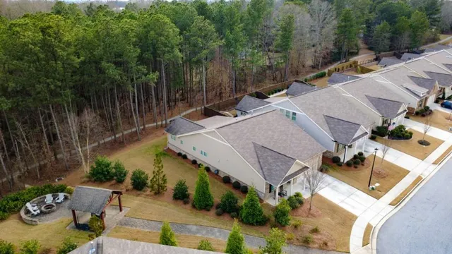 an aerial view of a house with swimming pool and large trees