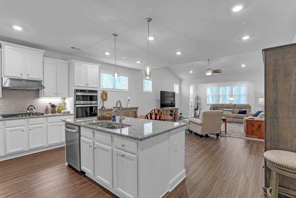 1598 Auburn Rdg Way Dacula, GA 30019 - Photo 5 of 34 a large white kitchen with stainless steel appliances granite countertop a lot of counter space and wooden floors