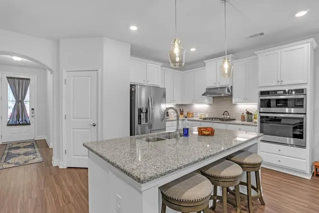 a kitchen with stainless steel appliances granite countertop a sink refrigerator and cabinets