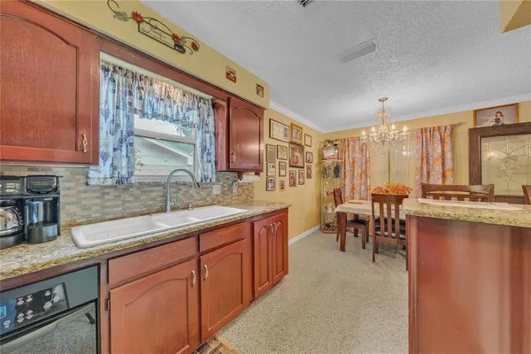 a bedroom with a bed a chandelier and dresser