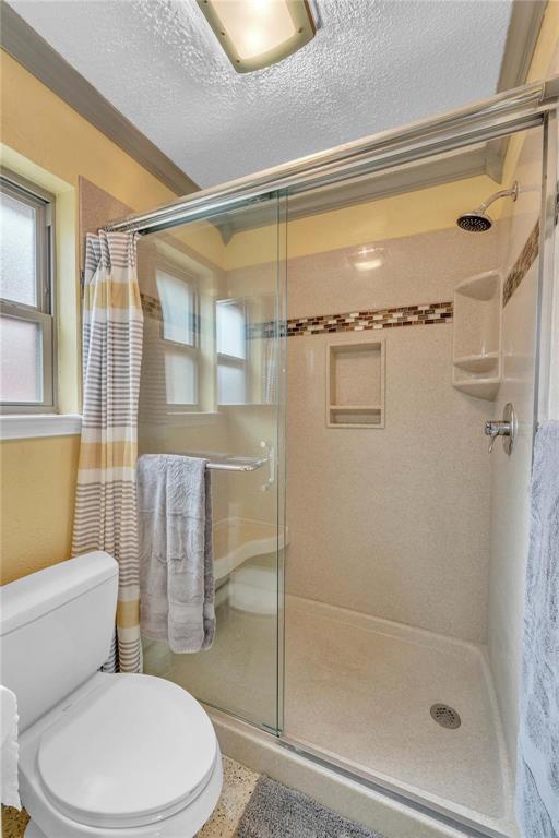 7613 Clover Lane Watauga, TX 76148 - Photo 19 of 36 Bathroom featuring a stall shower, a textured ceiling, and ornamental molding