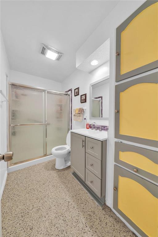 7613 Clover Lane Watauga, TX 76148 - Photo 21 of 36 Full bath featuring vanity, a shower with shower door, dark aggregate flooring, and light colored carpet