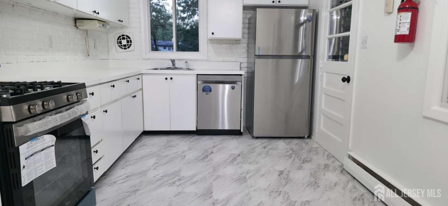 33 Nottingham Road Edison, NJ 08820 - Photo 3 of 6 a kitchen with a refrigerator and a sink