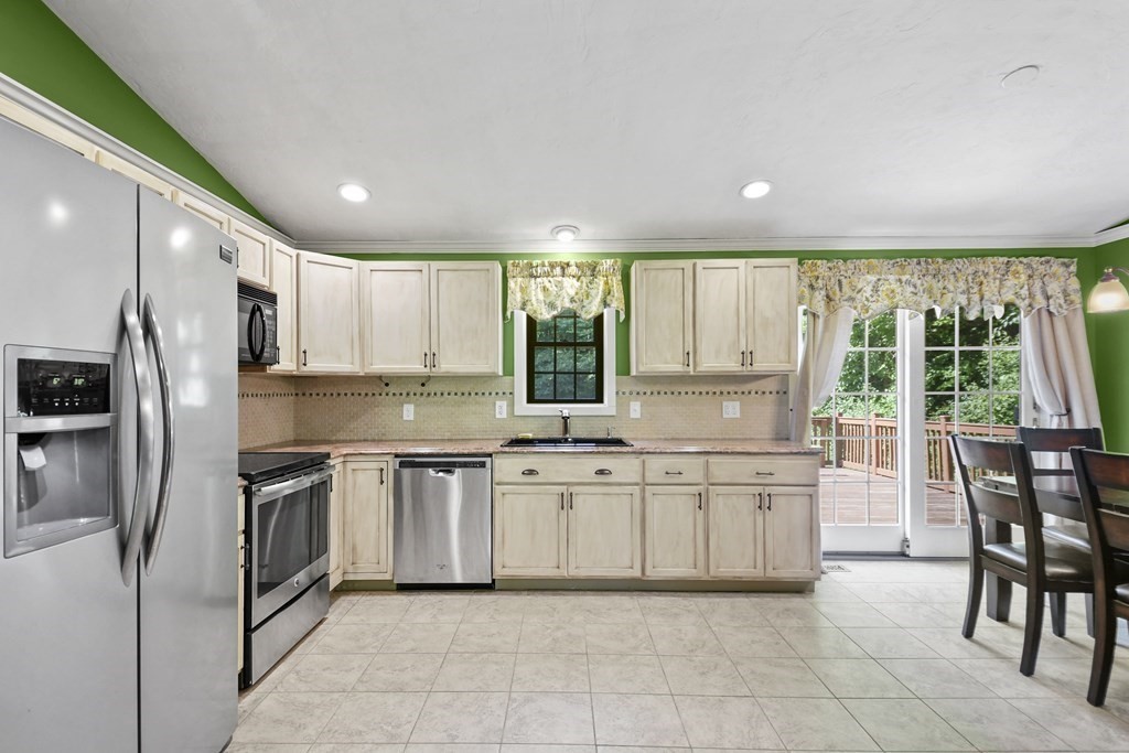 73 Hill Road Charlton, MA 01507 - Photo 9 of 32 a kitchen with stainless steel appliances granite countertop a stove top oven a sink dishwasher a dining table and chairs with wooden floor