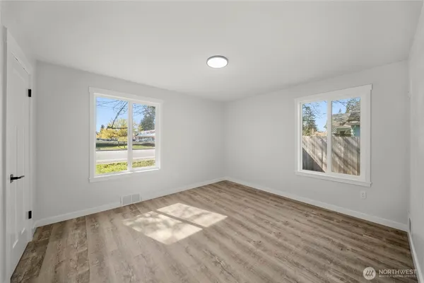 a view of an empty room with a window and closet