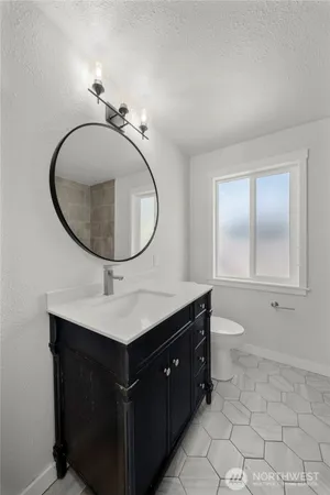 a bathroom with a toilet a sink and mirror