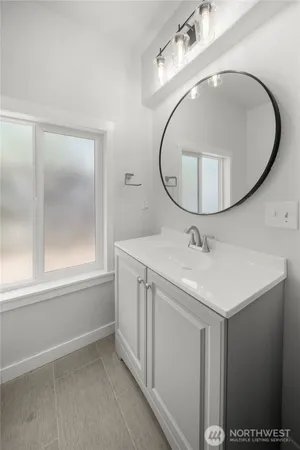 a bathroom with a sink a mirror and a vanity