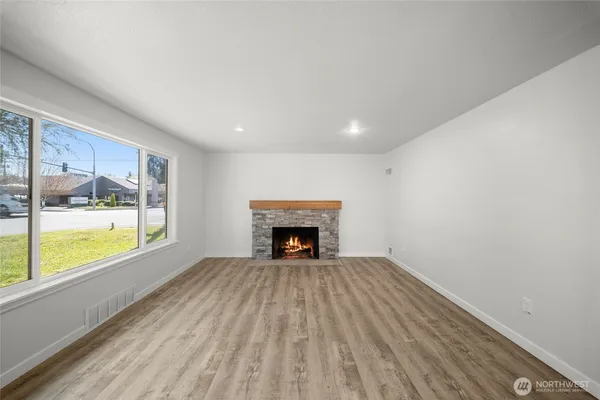 a view of an empty room with a fireplace and a window