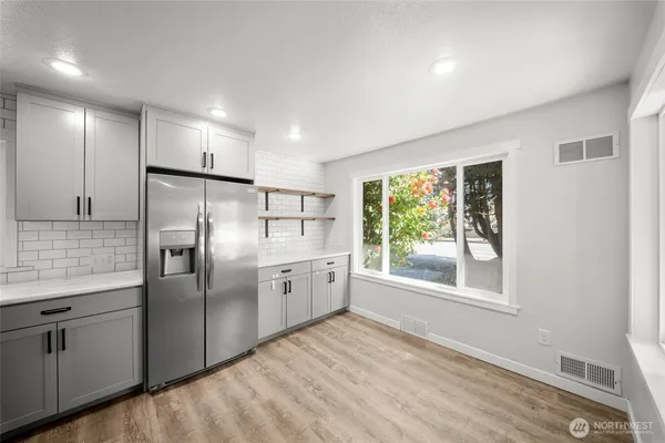 a kitchen with stainless steel appliances granite countertop a refrigerator and a stove top oven