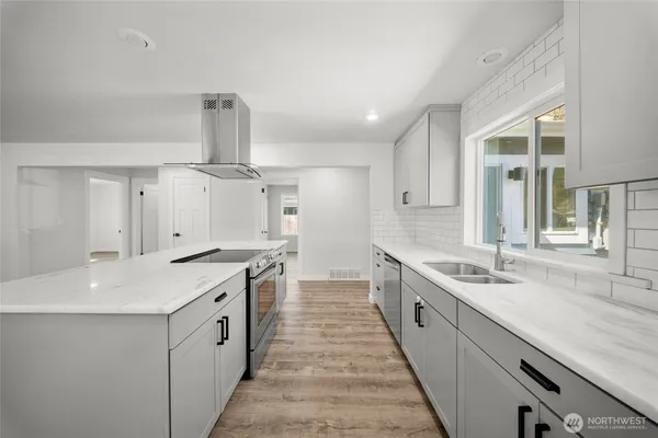 a large kitchen with a stove sink and cabinets