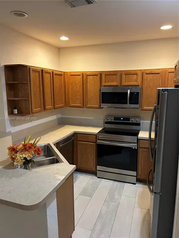 a kitchen with a sink appliances and cabinets